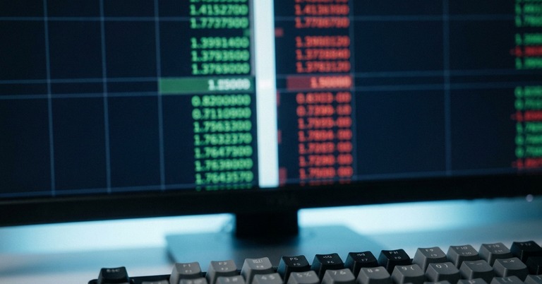 Trading monitor displaying green and red bid and ask prices above a keyboard